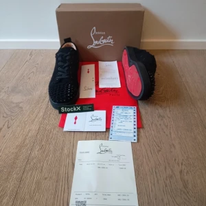 Christian Louboutin svarta sneakers med nitar - Säljer ett par svarta sneakers från Christian Louboutin i mocka med ikoniska röda sulor. Skorna är i bra skick med en fortfarande väldigt ren sula. Säljer till någon som äger extraspikar då en har fallit av, därav billigt pris. 