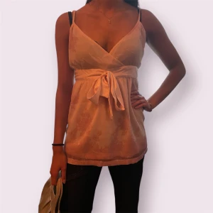 Ljusrosa omlott blus med knytband - Superfin ljusrosa blus med tunna axelband och omlott-design framtill! 