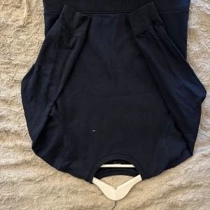 Mörkblå sweatshirt från Tommy Hilfiger - En stilren mörkblå sweatshirt från Tommy Hilfiger med diskret logga framtill och ribbade muddar vid ärmslut och midja. Klassisk passform och mjukt bomullsmaterial gör den perfekt för en chill och snygg look.