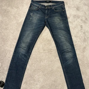 Mörkblå jeans från J.libdeberg - Säljer ett par mörkblå jeans från j.lindeberg med slitningar. Riktigt snygga och tyvärr lite för små på mig. Skicket på dom är riktigt bra. Jag är 188cm och de är ganska tighta på mig men funkar i längden. Nypris 1599kr. Hör av er vid funderingar;)