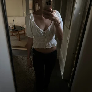 Vit blus med spets från ASOS DESIGN - Supersöt vit blus från ASOS DESIGN med puffärmar, spetsdetaljer och knappar framtill. Croppad modell med volangkant nertill och v-ringad hals. Tillverkad i tunn bomull med broderade detaljer på ärmarna. Perfekt för en romantisk look! Den är i bra skick, pris kan diskuteras🥰