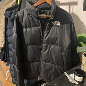  The North Face jacka - Säljer en svart pufferjacka från The North Face. Jätte fint och fräsch. Jag har inte använt den på jättelänge. Den e jättefräsch som sagt men det går inte bara att tajta till annars är den perfekt.