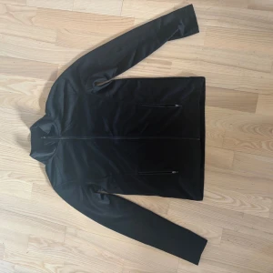 Svart sportig jacka - Svart, stilren sportjacka från Active Sport med hel dragkedja i storlek 158/164 men är som en S. Jackan har lång ärm och en smal, hög krage.  Den är inte använd någon gång då den är förstor för mig. Kontakta mig om du har några funderingar!!❤️