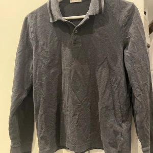 Mörkgrå långärmad pikétröja Moncler - Mörkgrå långärmad pikétröja från Moncler med krage.