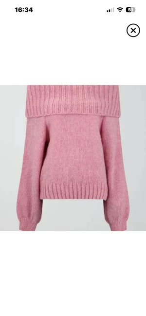 Rosa offshoulder stickad tröja - Säljer en supermysig rosa stickad tröja med bred ribbad kant upptill som sitter offshoulder. Tröjan har långärmade ärmar med ribbade muddar och en loose passform. Perfekt för dig som gillar chill och snygg stil.