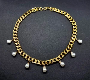 guldhalsband med pärldroppar - Halsband i guldtonad metall med sju droppformade vita pärlor som hänger längs kedjan. Kedje storlek 9mm. 40 cm, rostfritt stål.                                                    