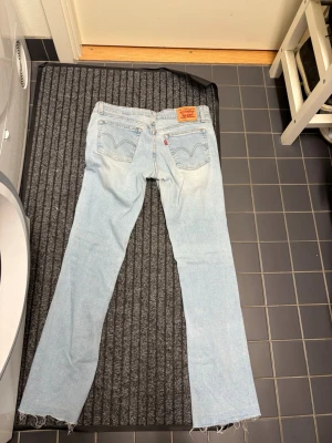 Levi's 518 Superlow Stretch ljusa jeans - Säljer ett par ljusblå Levi's 518 Superlow Stretch som är bootcut. Jeansen har låg midja och är tillverkade i stretchig denim för extra komfort. Perfekta för dig som gillar en avslappnad och trendig look.