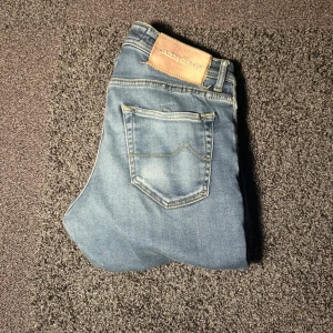 Jacob cohen jeans - Snygga ljusblå jeans från Jacob Cohen med slitna detaljer på benen och klassiska. Strl 31 riktigt bra skick!