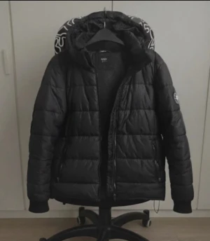 Everest vinterjacka / dunjacka - Vinterjacka från everst. Storlek 158 dvs 79 cm bröst. Borttagbar huva och två fickor på utsidan samt en ficka på insidan. Justerbar tightness vid nedre änden (se sista bild). För frågor eller fler bilder är det bara att skriva till mig!