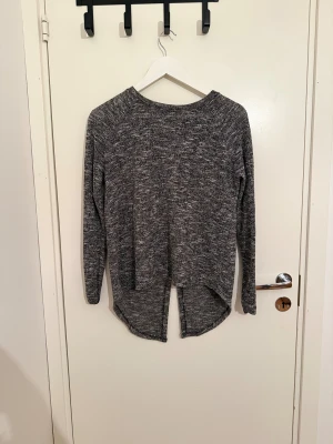 Grå stickad tröja med slits från Vila - Säljer en gråmelerad stickad tröja från Vila i storlek XS. Tröjan har lång ärm, rund hals och cool slits både fram och bak som ger en snygg look. Perfekt för dig som gillar chill och stilren design.