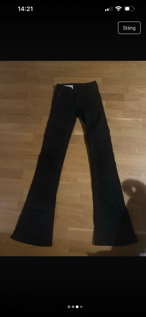Svarta bootcut jeans från Cheap Monday - Säljer ett par svarta bootcut jeans från Cheap Monday med ikonisk dödskallepatch i rosa bak. Klassisk femficksmodell med normal passform och utsvängda ben. Perfekta för dig som gillar en edgy och retro vibe.