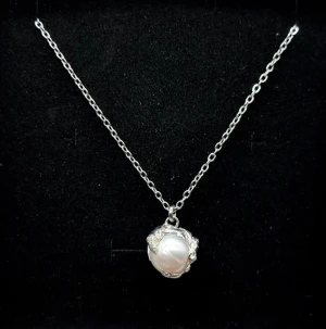 Silver 925 halsband med havspärla - Handgjort halsband inspirerat av Maria Nilsdotter. Hänget är gjort av en silver 925- och rostfri metallblandning med en naturlig havspärla, storlek 1,5 cm. Kedjans längd – 46 cm.