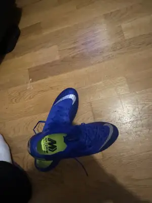 Säljer ett par Nike Mercurial Vapor360 fotbollsskor i starkt blå färg med silverdetaljer och snörning. Skorna har en rund tå och platt sula med avancerad dobbsystem för grymt grepp på planen. Insidan är neonfärgad med NikeGrip-teknologi för extra komfort och stabilitet.