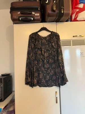 Odd molly blus  - Säljer en otroligt vacker mörkgrå blus med ett fint detaljerat blommig mönster i jordnära färger. Bottenfärgen kan i vissa ljus så svart ut men den ör mörkgrå. Storlek 4 som enligt deras storleksguide motsvarar en XL. Mycket fint skick, jag hittar inga synliga anmärkningar eller defekter. 