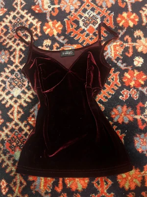 Vinröd sammets linnetopp Des Anges - Supersnygg vinröd linnetopp från Des Anges i mjuk sammet.erfekt för dig som vill ha en elegant och trendig look med lyxig känsla. Passar till både jeans och kjol! Toppen funkar som storlek S/M