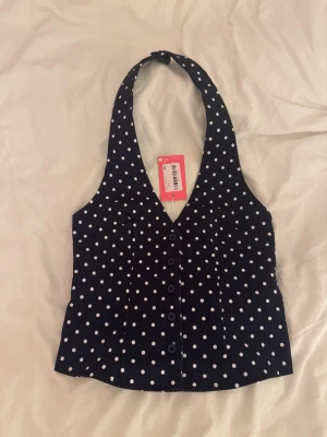 Mörkblå prickig halterneck - Mörkblå prickig halterneck från edikted som är för stor på mig! Helt ny med lappen kvar och pris kan alltid diskuteras 🥂  Vill få bort så mycket som möjligt så kika gärna in mina andra plagg