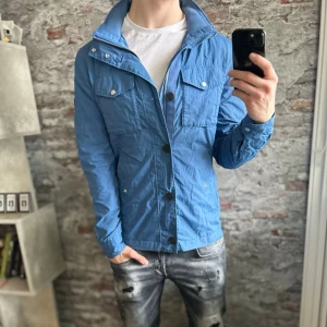 J.lindeberg Field Jacket - Mycket fint skick, inga defekter(lite skrynklig bara). Storlek M passar dig som är mellan 175-185cm ungefär. Nypris ca 4000kr. Modellen är 185 cm, 79 kg. Passar bra nu till vind och regn. Skriv för mer information!🤝