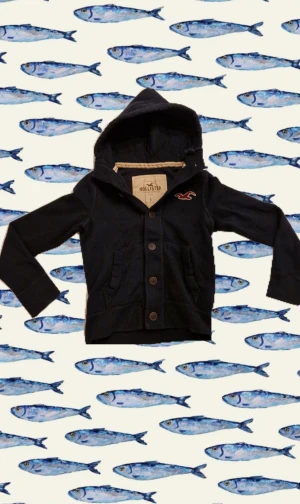 Hollister cardigan hoodie blå med knappar - En hollister cardigan/hoodie med luva och knappar i bra skick! Kolla sista bilderna för små små defekter (syns inte när du har den på dig. Storlek S passar även XS. Sjukt vintage hoodie som inte går att få tag på längre. Mvh Afex Closet