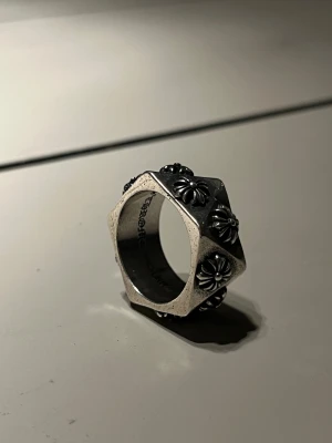 Silvrig Chromehearts Ring - Säljer min chrome ring. Aldrig använt den och är felfri. Med kommer ingen chrome hearts påse eller liknande så lite billigare än vad jag tidigare säljer dem för. Stl 10