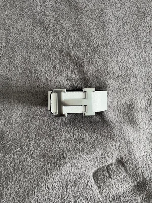 Hermès bälte  - Säljer ett vändbart Hermès-bälte i svart och vitt skinn med klassiskt H-spänne i silverfärgad metall. Bältet har en stilren och lyxig känsla, perfekt för att lyfta vilken outfit som helst.  Märkt med storlek 115.