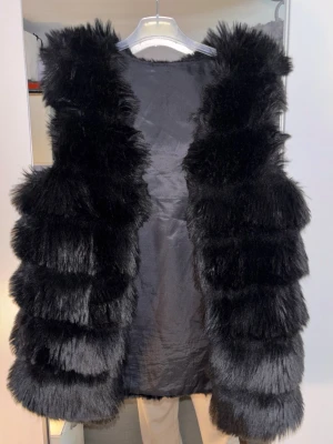 Svart fluffig pälsväst - En svart pälsväst med fluff. 