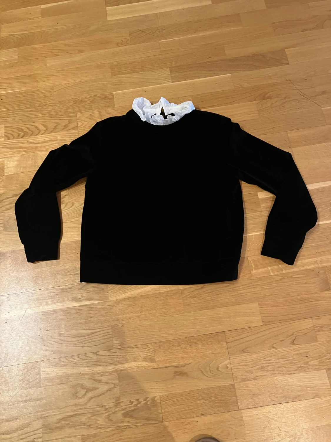 Svart sammetströja med vit volang