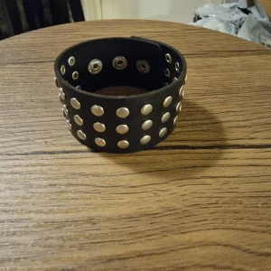 Armband punk - Enkel rund nit PU-läderarmband för män och kvinnor. 21,8 cm lång. Bredd 3,5 cm. Armbandet har tryckknappar för enkel stängning och ett edgy, rockigt utseende. Perfekt för dig som vill sticka ut med en unik accessoar.
