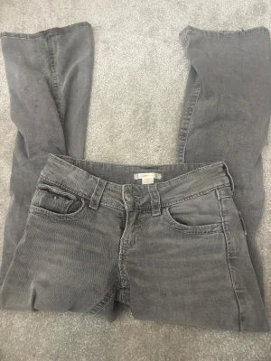 ginatricot bootcut jeans 146cm - Ett par gråa bootcut jeans från GinaTricot i storlek 146 med detaljerade fickor samt en liten ficka där fram på byxorna, dem är lite svarta ner på benet men inget som märks av riktigt. 