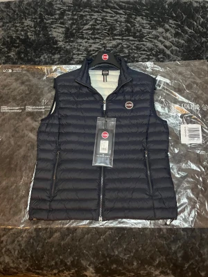 Marinblå Colmar Väst - Tja! Säljer nu denna riktigt schyssta Colmar Västen i färgen ”Navy Ice”. Påse, Klädhängare och Lappar ingår! Västen är i princip i nyskick, endast använd fåtal gånger. Storlek 52, sitter som M/L. Hör av dig vid minsta fråga eller fundering!🌟