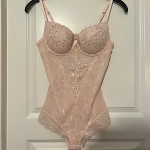 rosa body - (RESERVERAD) supersnygg ljusrosa body från lindex med glittriga stenar och spetsdetaljer💓storlek 80B, passar S-M