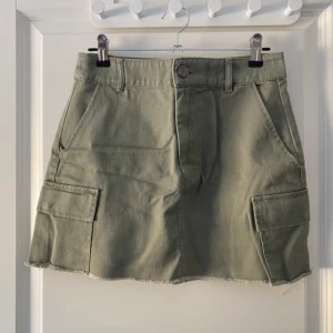 Grön cargokjol från Pull&Bear - Supersnygg khakigrön cargo-kjol från pull and bear i storlek S! Perfekt att matcha med sneakers eller boots.  Vänligen läs min bio innan du gör ett köp; där hittar du bland annat information om leveransprocessen med mera 😊   Midja: 34cm Längd: 36cm  #cargokjol  #pullandbear  #trendigt  #fashion  #grönkjol  #stoclholmstyle .