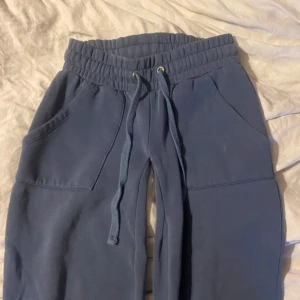 Blå mjukisbyxor med snörning - Blå mjukisbyxor med bred resår i midjan och snörning framtill. Byxorna har två stora fickor fram och en bakficka. Tillverkade i mjukt bomullsmaterial, perfekta för en avslappnad stil. Jag har sytt dom lågmidjade själv.