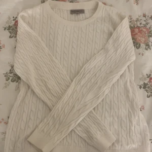 Vit kabelstickad tröja Basic You - Säljer en vit kabelstickad tröja från Basic You (Ullared) i storlek M. Tröjan är gjord av ekologisk bomull, har rund hals och långa ärmar med ribbade muddar. Perfekt för dig som gillar klassisk och enkel stil med snygg struktur.