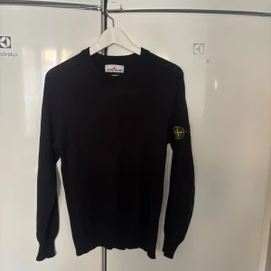 Stone island stickad crewneck - Svart långärmad tröja från Stone Island med klassisk rund hals och ikonisk logga på ärmen. Tillverkad i en mjuk blandning av bomull och polyamid, perfekt för dig som gillar stilrena och snygga plagg med streetkänsla. Inga defekter, mycket fint skick. Nypris ca 5000, mitt pris 1200. Kom privat för mer frågor!