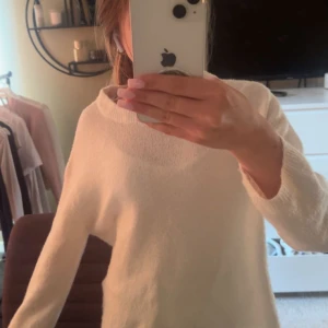 Vit stickad tröja med lös passform - Mysig vit stickad tröja med rund hals och lång ärm. Tröjan har en lös och avslappnad passform, perfekt att slänga på sig när det är kyligt. Enkel och stilren design som är lätt att matcha med olika outfits.