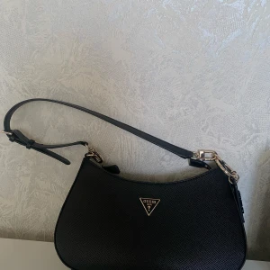Svart axelväska från Guess - Ny väska köpte från Åhléns. Jag säljer den för att rensa ut min garderob.