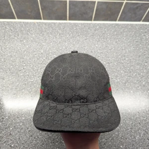 Svart keps från Gucci med GG-mönster - Svart Gucci keps i perfekt skick.