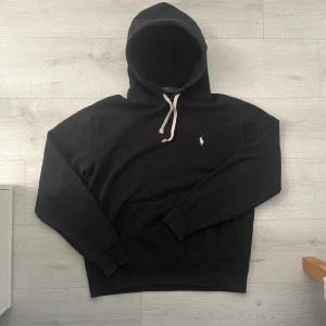 Ralph lauren hoodie  - Hej! Säljer en Ralph lauren hoodie i färgen svart//Hoodie är i fint sick men har ett pyttelitet hål under armhålan men inget man märker av om man inte kollar noga//tröjan är i strl M//personen på bilden är 180cm lång och väger mellan 65-70kg//hör av dig vid frågor eller sånt!🤩