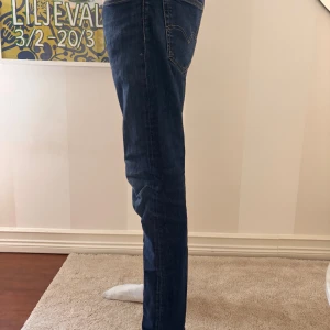 Levi's 512 blå jeans W33 L32 - Säljer ett par Levi's 512 jeans i klassisk blå denim. Modellen har en slim passform med något avsmalnande ben och normal midja. Jeansen har fem fickor, snygga kontrastsömmar och är tillverkade i bomull med en liten stretch för extra komfort. Pris går alltid att diskutera😁