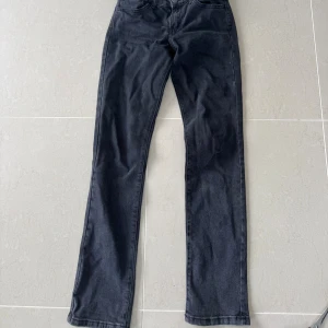 Svarta jeans från Stradivarius - Snygga svarta jeans från Stradivarius med klassisk femficksdesign och raka ben. Jeansen har normal midja och är tillverkade i ett mjukt bomullsmaterial med lite stretch för extra komfort. Perfekta för en stilren och enkel look.