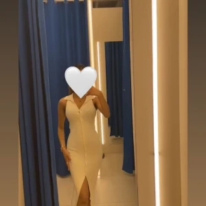 Krämvit figurnära klänning från bershka  - Säljer en krämvit, figurnära klänning med klassisk krage och snygg slits framtill. Klänningen är ärmlös och har en stilren, minimalistisk look som känns både modern och chic. Perfekt för dig som gillar en enkel men elegant stil. 