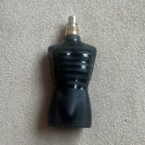 Stilren parfymflaska i svart design 60ml kvar - En ikonisk parfymflaska formad som en torso i svart med randigt mönster. Perfekt för dig som vill sticka ut med en modern och trendig accessoar på hyllan. Volym och ingredienser syns ej på bilderna.