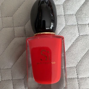 Sì Passione parfym - Sì Passione från Giorgio Armani – en ikonisk parfym i snygg röd flaska. Perfekt för dig som vill sticka ut och visa attityd. 1/3 del