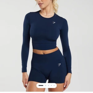 Mörkblå långärmad croppad topp Gymshark - Säljer en mörkblå långärmad croppad topp från Gymshark. Toppen har en tight passform, rund halsringning och diskret logga på bröstet. Perfekt för träning eller sportiga outfits. Materialet är stretchigt och följsamt för maximal rörelsefrihet. Nytt skick och kostar 350kr