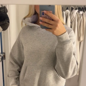 Grå hoodie från Ginatricot med tryck - Grå hoodie från Ginatricot med blått tryck på ryggen. Modellen är oversized så köpte i xs och sitter luftigt på mig💕 
