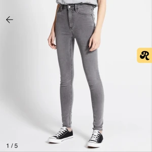Grå skinny jeans med hög midja - Snygga grå jeans med skinny passform och hög midja. Byxorna har klassisk femficksdesign, knapp och dragkedja framtill. Perfekta för dig som gillar en tajt siluett och stilren look.