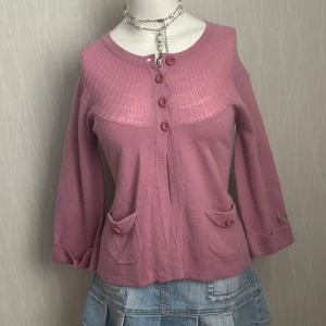 Rosa kofta från Stockh LM i ullmix - Supersöt rosa kofta från Stockh LM med rund hals, dekorativa knappar framtill och två fickor med lock. Stickad i en mjuk mix av ull och akryl, perfekt för lager på lager. Snygg ribbad detalj upptill och långa ärmar.