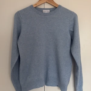 Ljusblå kashmirtröja från Davida - Säljer en jättefin Davida kashmir tröja. Den har ett litet hål i armhålan som man lan se på bild tre, men är i övrigt i bra skick. 