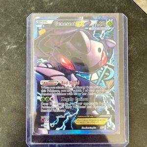 Genesect EX - Cool och kraftfull Pokémon EX-kort med Genesect! Perfekt för samlare och spelare som vill boosta sitt deck med en legendarisk Team Plasma Pokémon. Kortet har unika förmågor och en snygg, glittrande design som sticker ut i samlingen.