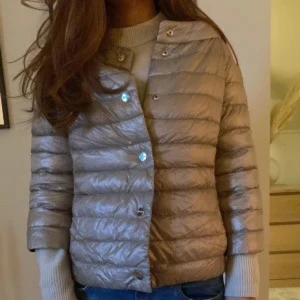 Beige dunjacka med knappar - Säljer min snygga beige dunjacka från Herno. Köpt för 4000 på Plick. Jackan har en lätt glansig finish och är midjekort med lång ärm.  I ett väldigt bra skick! Bara fråga för mer bilder 😇